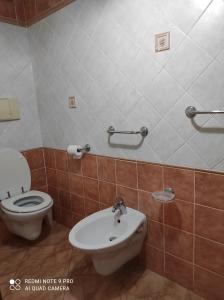 a bathroom with a toilet and a sink at MONOLOCALE YELLOW in Siniscola