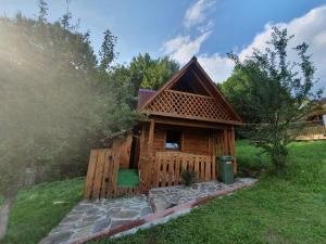 a small wooden cabin in a yard with a fence at Трембіта in Rakhiv