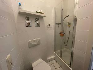 een witte badkamer met een douche en een toilet bij LE-Citywohnung-II in Leipzig