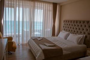 Un pat sau paturi într-o cameră la Hotel Frojd - Beach Front Resort