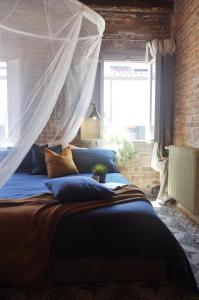 Schlafzimmer mit einem Bett mit Moskitonetz in der Unterkunft Maison du Flâneur in Chioggia