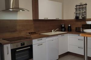 a kitchen with white cabinets and a stove top oven at Le Gite de Myla au pied du Château Royal d'Amboise in Amboise