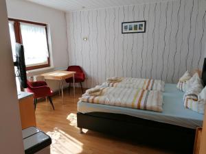 - une chambre avec un lit, un bureau et une télévision dans l'établissement Pension und Bistro" Dat olle Fischerhus", à Ralswiek