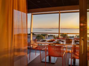 una sala da pranzo con tavolo e vista sull'oceano di 3 Olive Trees ad Anávissos