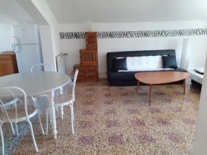 sala de estar con mesa y sofá en Venise Languedocienne, en Sète