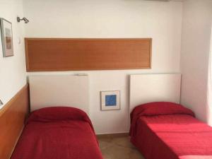 a bedroom with two beds with red sheets at Nice and quiet flat in Premià de Mar HUTB in Premiá de Mar