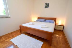 - une chambre avec un lit doté d'oreillers bleus dans l'établissement Apartment Mirela, à Malinska