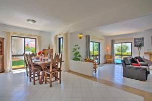 een eetkamer en een woonkamer met een tafel en stoelen bij Villa Jorge by Villa Plus in Albufeira