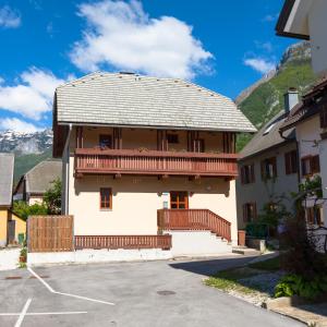 a building with a balcony with mountains in the background at Thirsty River Apartments in Bovec