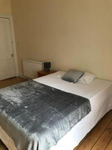 a bedroom with a bed with a silver blanket on it at Apex Haymarket Apartment in Edinburgh