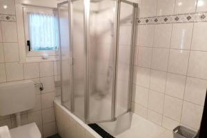 a shower with a glass door in a bathroom at Ferienwohnung Ankerplatz am Sorpesee in Langscheid