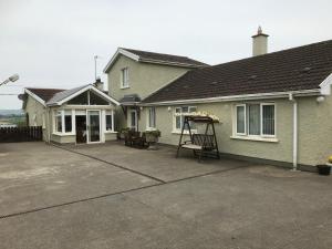 a house with a porch with a swing at Deeleview apartment in Lifford