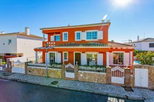 una casa naranja con una valla delante de ella en Villa Pera by Villa Plus, en Pêra
