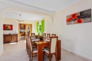 uma sala de jantar com uma mesa de madeira e cadeiras em Villa Pera by Villa Plus em Pêra