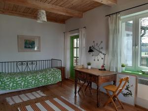 KrusznikにあるWakacje Wigryのデスク、ベッド、テーブルが備わる客室です。