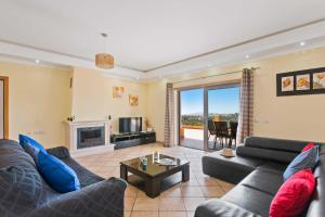 a living room with a couch and a fireplace at Villa Ribeiro Tomas by Villa Plus in Loulé