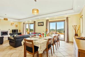 a dining room with a table and a living room at Villa Ribeiro Tomas by Villa Plus in Loulé