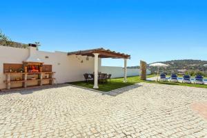 a patio with a fireplace and a table and chairs at Villa Ribeiro Tomas by Villa Plus in Loulé