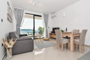ein Wohnzimmer mit einem Tisch und einem Sofa sowie ein Esszimmer in der Unterkunft Apartmani Porat in Igalo
