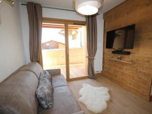 a living room with a couch and a flat screen tv at Appartement Hauteluce, 3 pièces, 6 personnes - FR-1-293-268 in Hauteluce