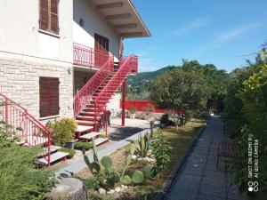 una casa con escaleras rojas en un jardín en San Casciano, en Narni