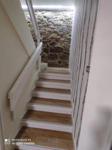 a staircase in a house with a stone wall at Casa Pepa in Corcubión