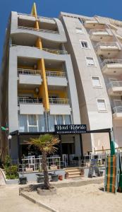 un bâtiment avec un palmier en face dans l'établissement Hotel Klebrido, à Durrës