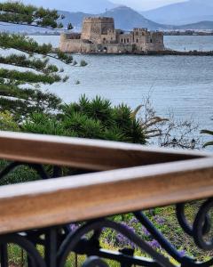 a bench in front of a castle in the water at Impero Nafplio Hotel & Suites in Nafplio