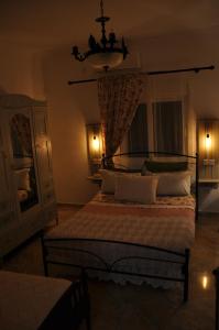 a bedroom with a large bed and a chandelier at KD Vintage Home in Lávrion