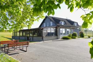 a building with two benches in front of it at Hotel-Restaurant U Švábků in Tachov