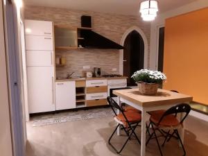 une cuisine avec une table avec deux chaises et une table avec des fleurs dans l'établissement Villa Genna, à San Vito Lo Capo