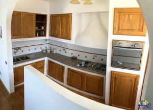 a kitchen with wooden cabinets and a stove top oven at Magi - Il Tramonto su Palmarola in Ponza