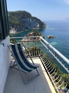 a chair sitting on a balcony overlooking the ocean at Magi - Il Tramonto su Palmarola in Ponza