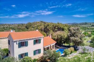 una vista aerea di una casa con piscina di NEW! Villa SAN with heated pool, traditional surroundings, 3-bedrooms a Nerežišće