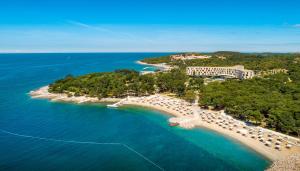 an aerial view of a beach with umbrellas and the ocean at Maistra Select Family Hotel Amarin in Rovinj +37 photos