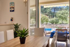 una sala da pranzo con un tavolo e una grande finestra di NEW! Villa SAN with heated pool, traditional surroundings, 3-bedrooms a Nerežišće
