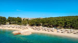 an aerial view of a beach with chairs and umbrellas at Maistra Select Family Hotel Amarin in Rovinj
