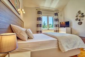 una camera da letto con un letto grande e una finestra di NEW! Villa SAN with heated pool, traditional surroundings, 3-bedrooms a Nerežišće Altre 29 foto
