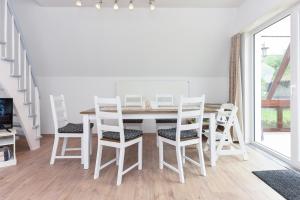 ein weißes Esszimmer mit einem Tisch und Stühlen in der Unterkunft Ferienhaus Windspiel in Neuharlingersiel