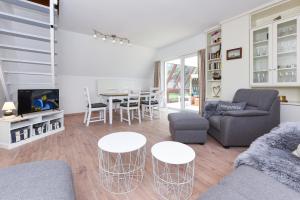 ein Wohnzimmer mit einer Couch und Stühlen und einem Tisch in der Unterkunft Ferienhaus Windspiel in Neuharlingersiel