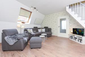 ein Wohnzimmer mit Couch und Fernseher in der Unterkunft Ferienhaus Windspiel in Neuharlingersiel