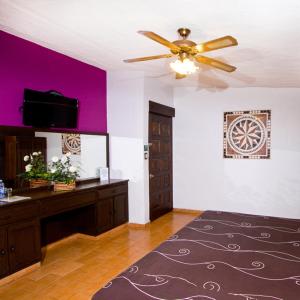 a living room with a ceiling fan and purple walls at Hotel & Motel Hacienda Jiutepec in Jiutepec