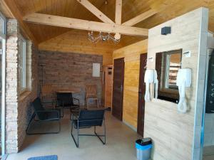 a living room with chairs and a brick wall at Willa Karo dom bliźniak 7-osobowy ZE STREFĄ BASENOWĄ w miejscowości Chocznia NIEDALEKO ZATORU I ENERGYLANDII in Chocznia