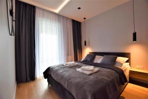 1 dormitorio con 1 cama grande y 2 toallas. en Premium Apartments Rzeszów, en Rzeszów