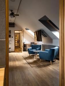 a living room with blue chairs and a table at Tűztorony apartman in Veszprém