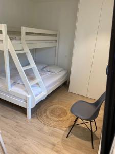 a small bedroom with a bunk bed and a chair at L'aVentouxre in Malaucène