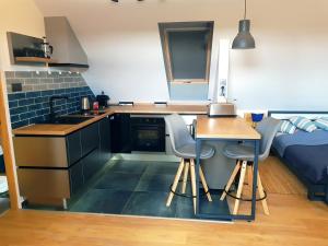 a small kitchen with a table and chairs and a bed at Tűztorony apartman in Veszprém