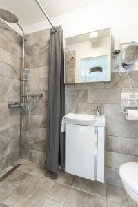 uma casa de banho com um chuveiro, um lavatório e um WC. em Nordsee-Pension Dagebüll em Dagebüll