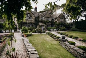 an exterior view of a house with a garden at Holdsworth House Hotel in Halifax