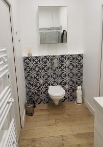 a bathroom with a toilet and a black and white tiles at Chambre de charme à Saulieu in Saulieu
